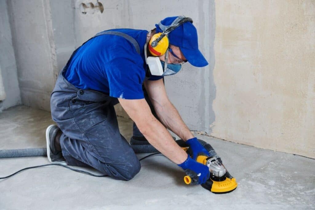 Perth Epoxy Group employee grinding floor before applying Epoxy flooring North Perth