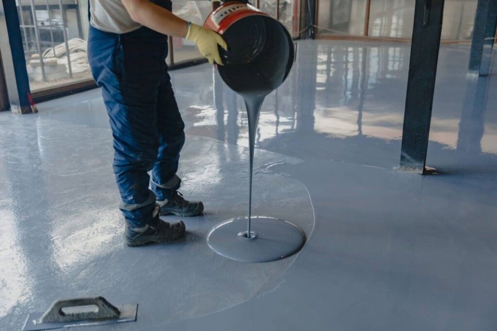 Perth Epoxy Group worker applying grey epoxy flooring