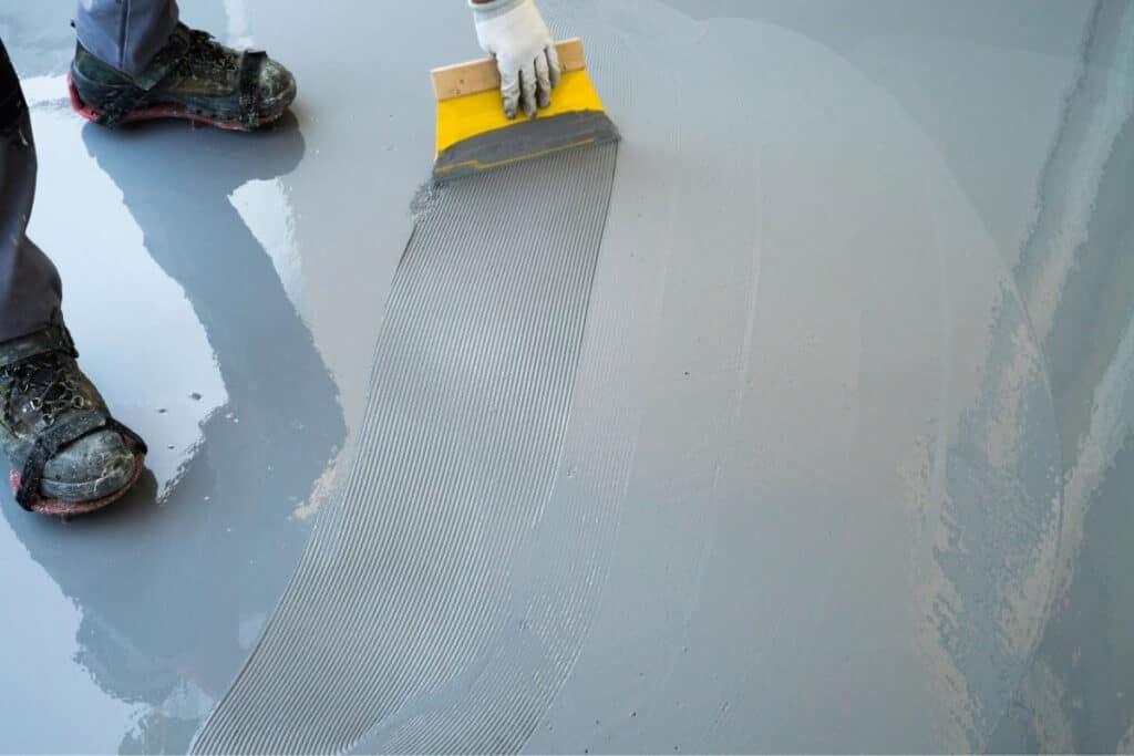 Perth Epoxy Group worker spreads Floor Epoxy Coating in Maddington home balcony Perth WA